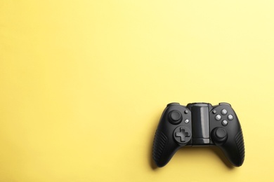 Photo of Modern video game controller on color background, top view with space for text