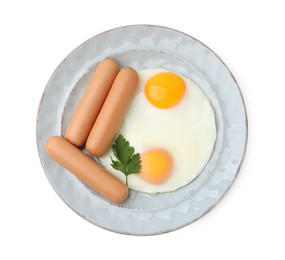 Delicious boiled sausages, fried eggs and parsley isolated on white, top view