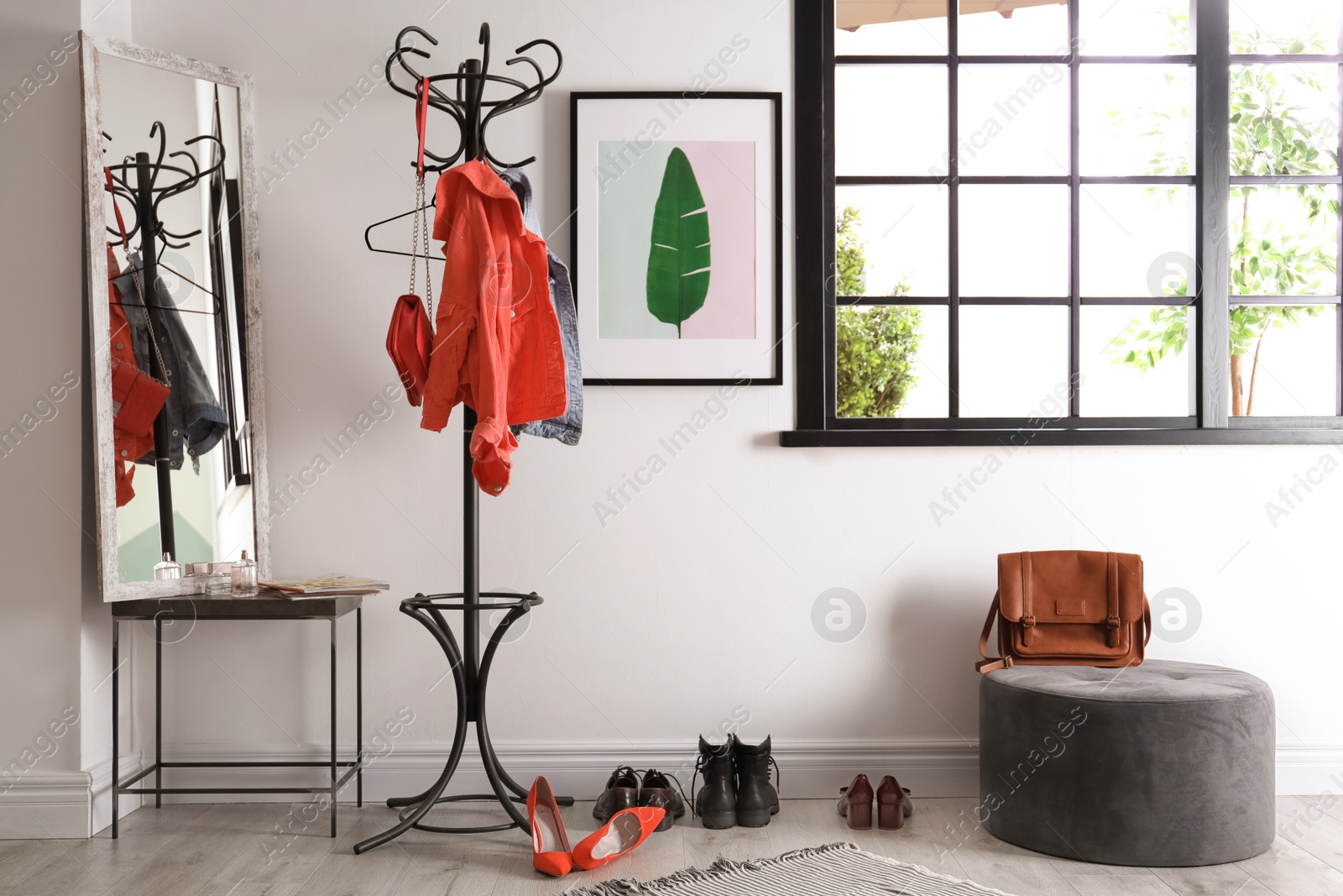 Photo of Modern hallway interior with clothes on hanger stand and mirror