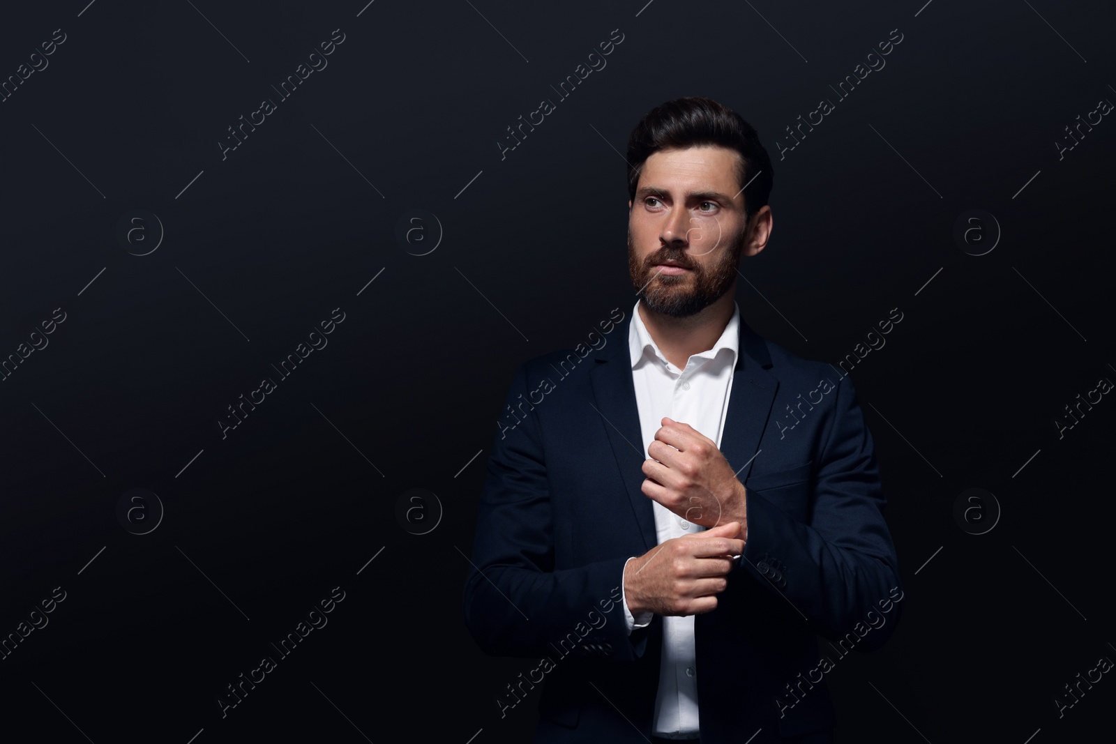 Photo of Portrait of handsome bearded man looking away on black background. Space for text