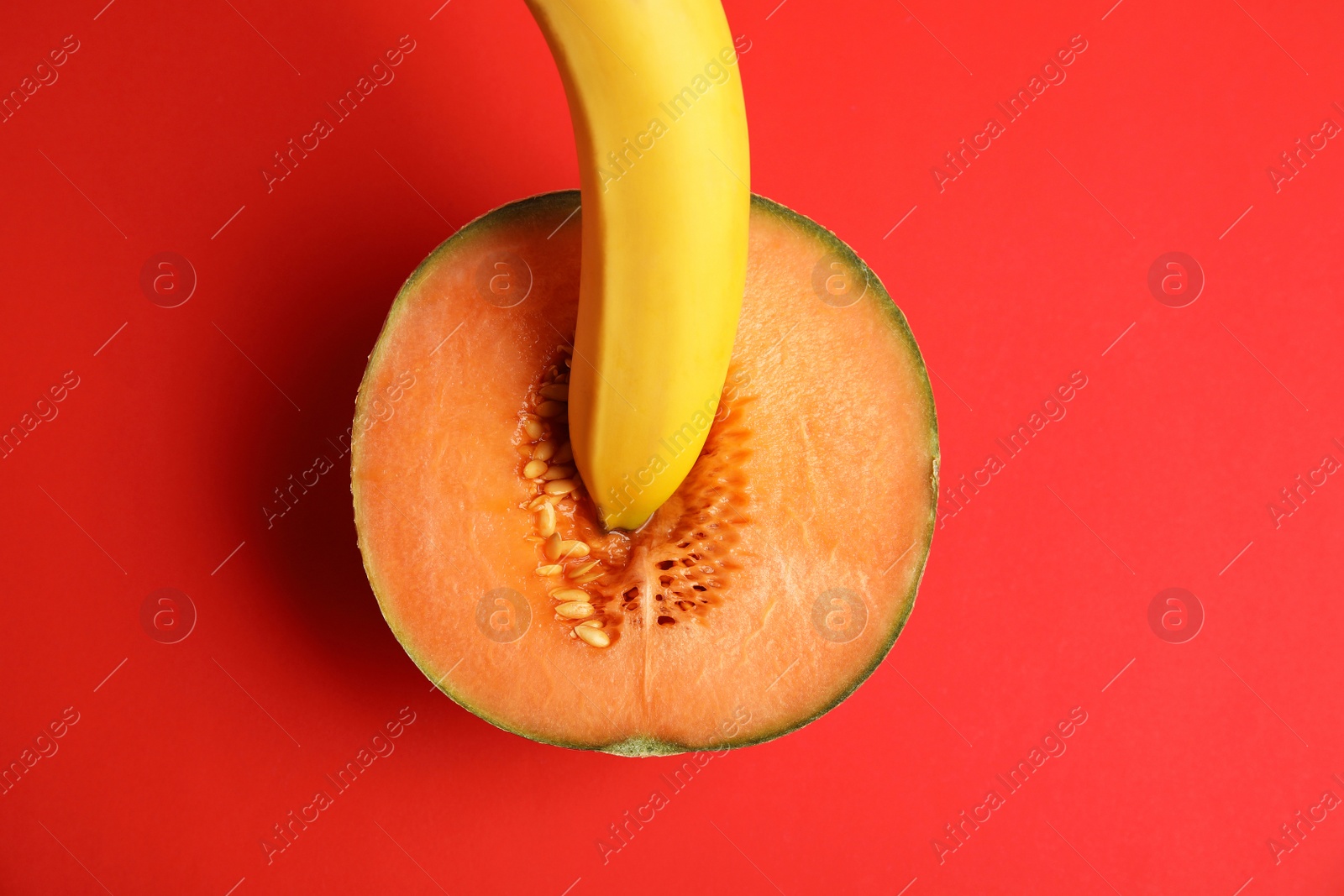 Photo of Flat lay composition with fresh banana and melon on red background. Sex concept