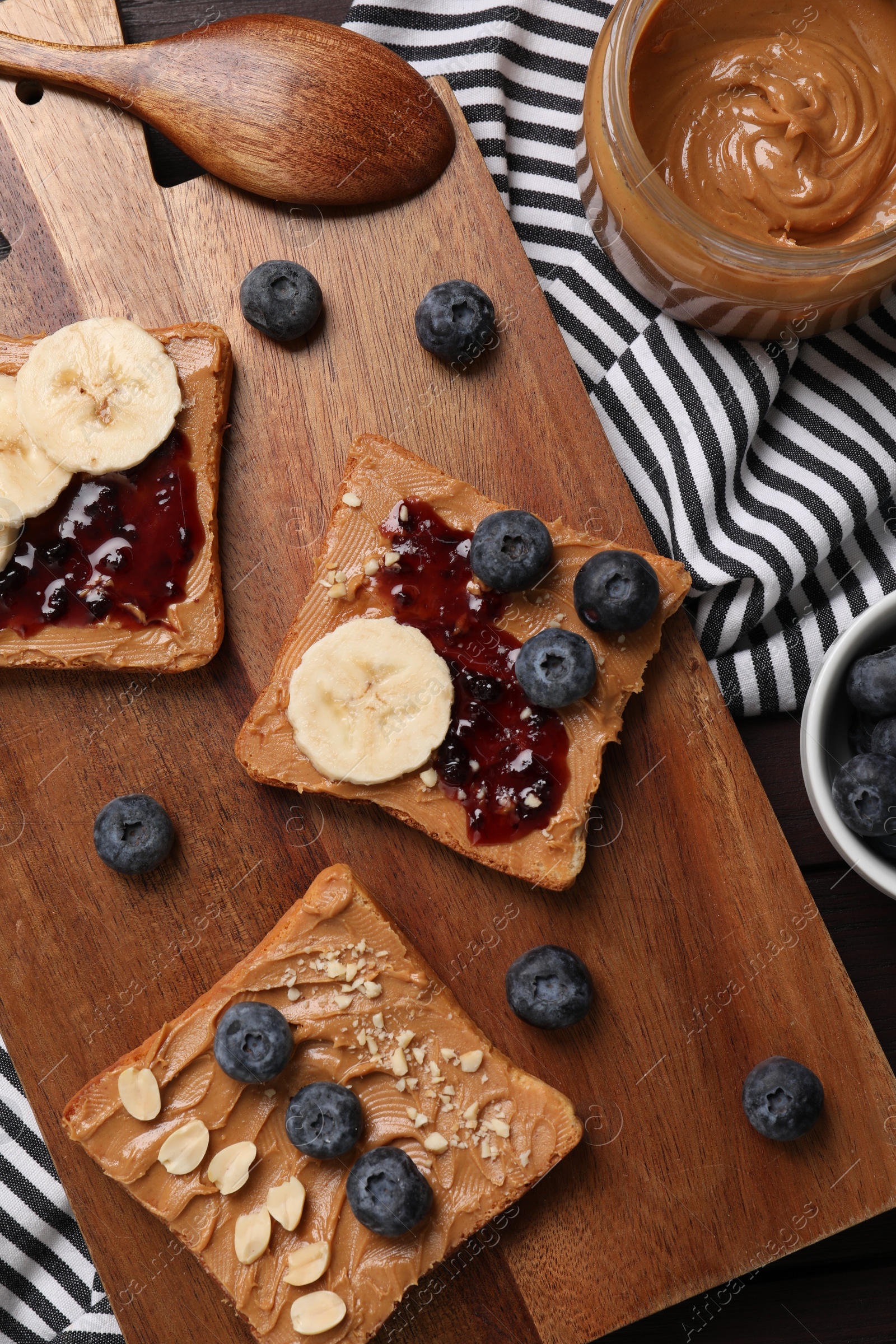 Photo of Different tasty toasts with nut butter and products on table, flat lay