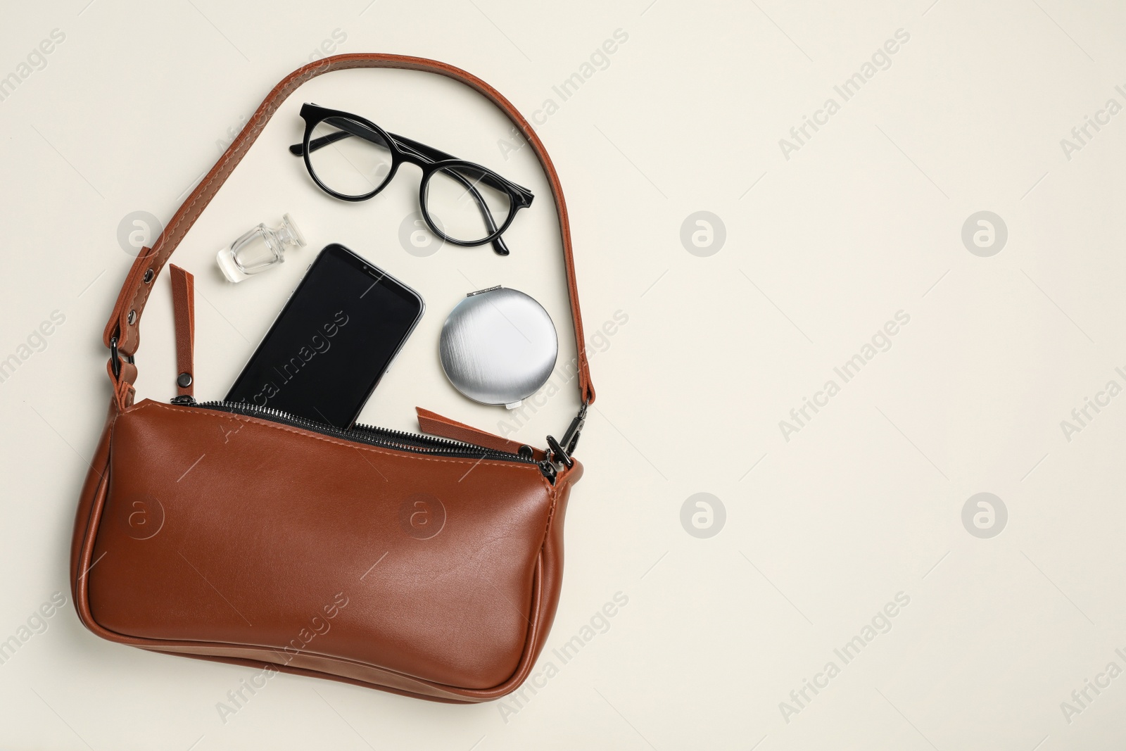 Photo of Stylish women's bag and different stuff on white background, flat lay. Space for text