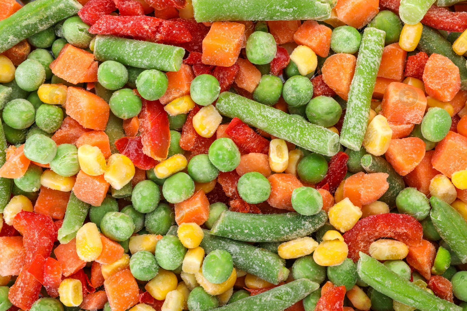 Photo of Mix of different frozen vegetables as background, top view