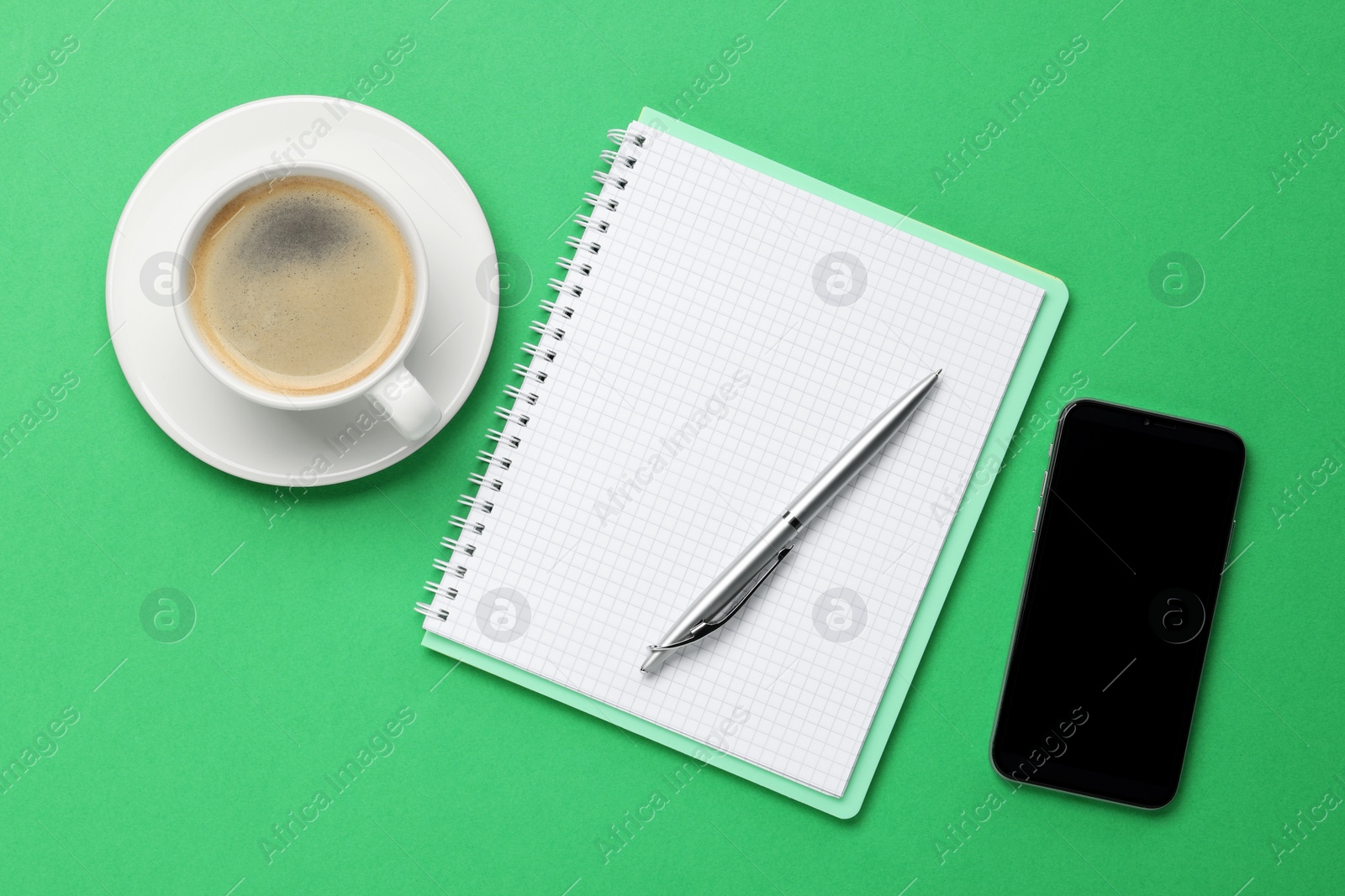 Photo of Ballpoint pen, notebook and smartphone on green background, flat lay