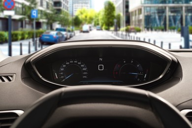 Image of Dashboard with speedometer behind steering wheel inside car