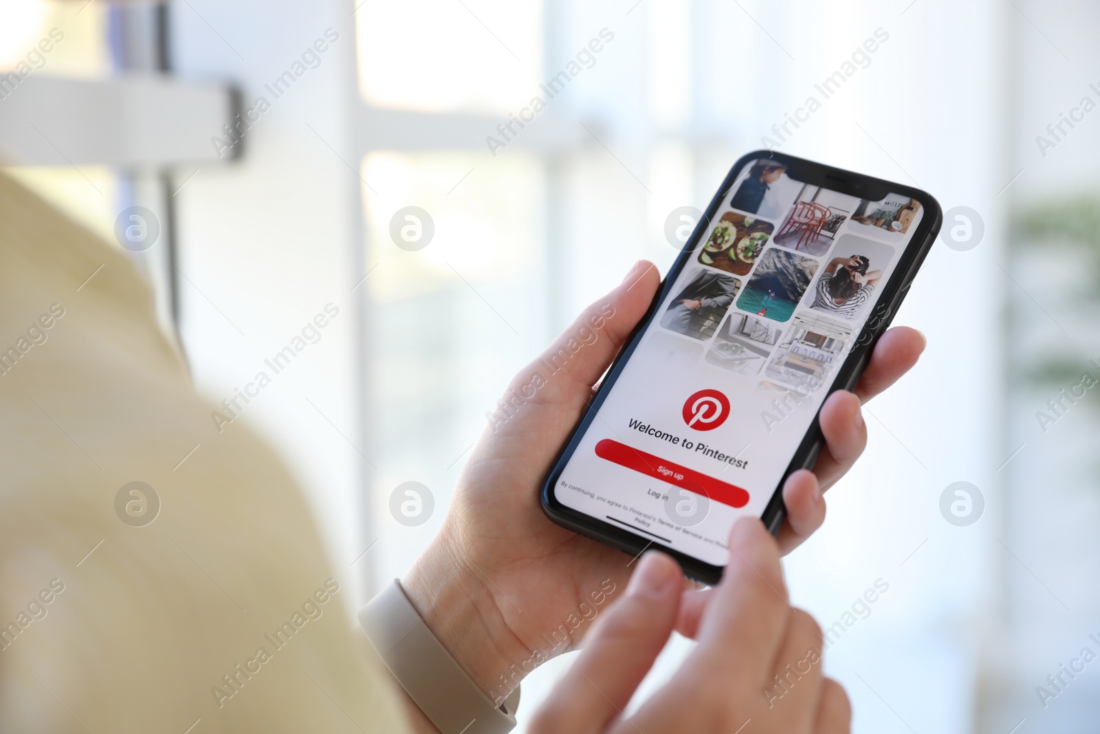 Photo of MYKOLAIV, UKRAINE - MARCH 16, 2020: Woman holding iPhone 11 with Pinterest app on screen indoors, closeup
