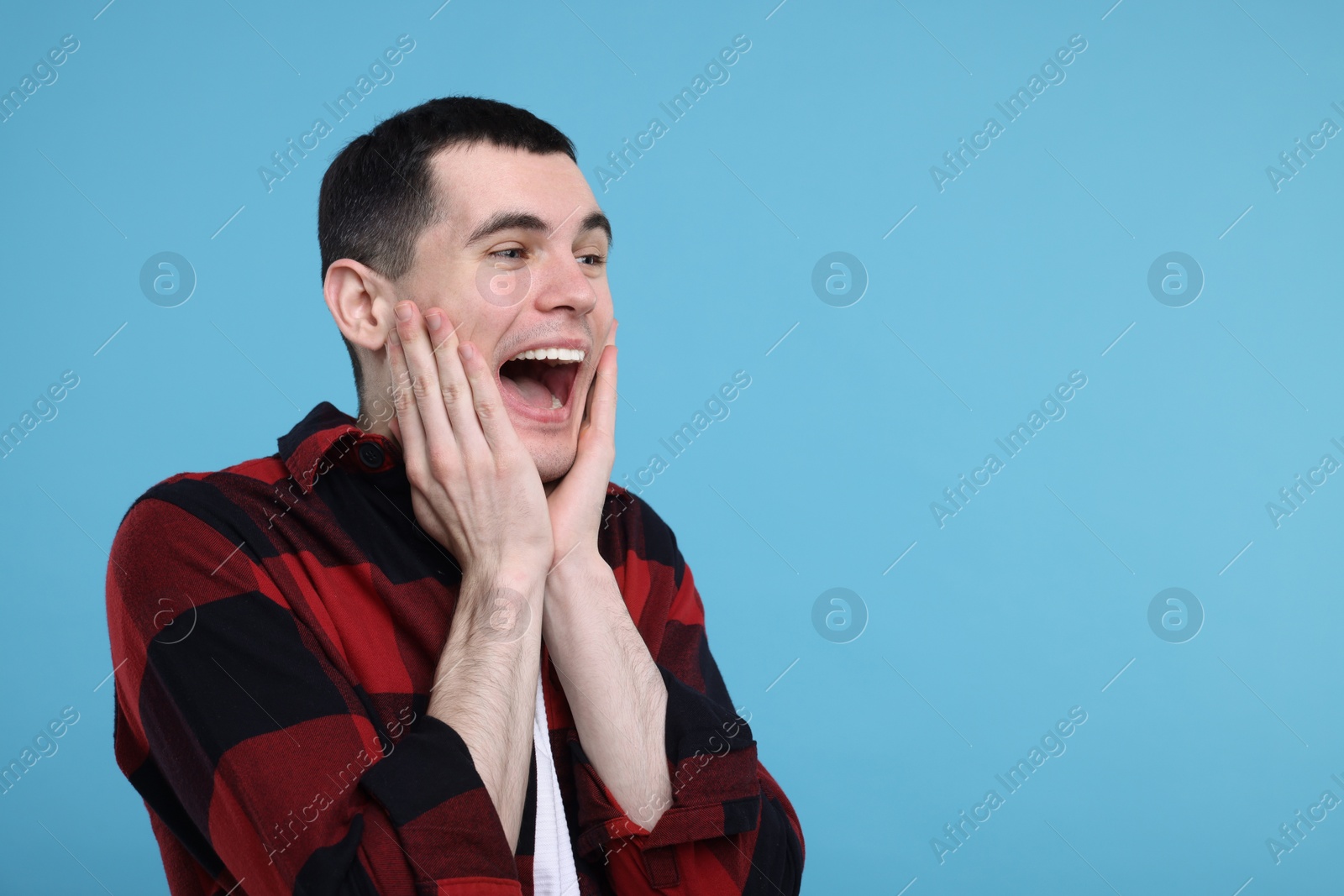 Photo of Portrait of surprised man on light blue background, space for text