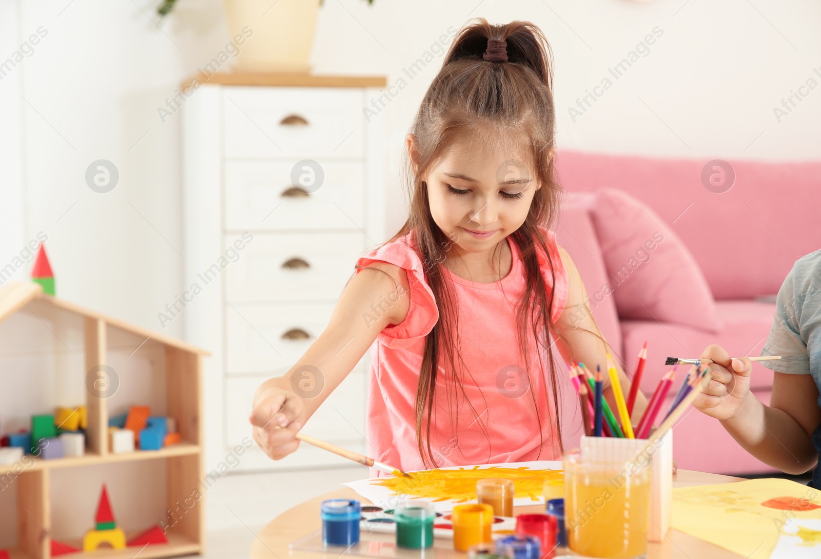 Photo of Cute little children painting at table in playing room