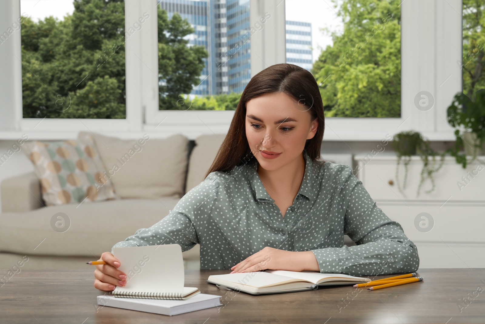 Photo of Woman with notebook at wooden table indoors