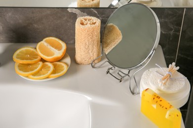 Lemon face wash. Fresh citrus fruits, personal care products and mirror on sink in bathroom