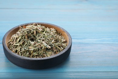 Photo of Bowl with aromatic dried lemongrass on light blue wooden table, closeup. Space for text