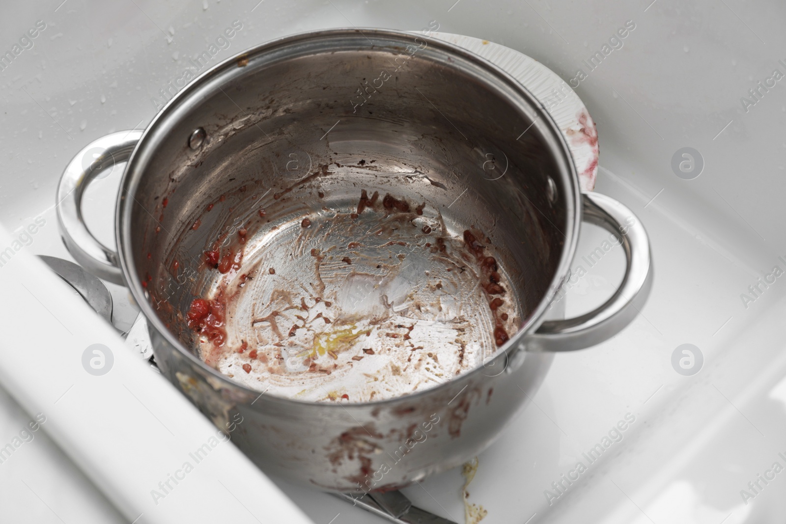 Photo of Sink with dirty metal pot in kitchen, closeup