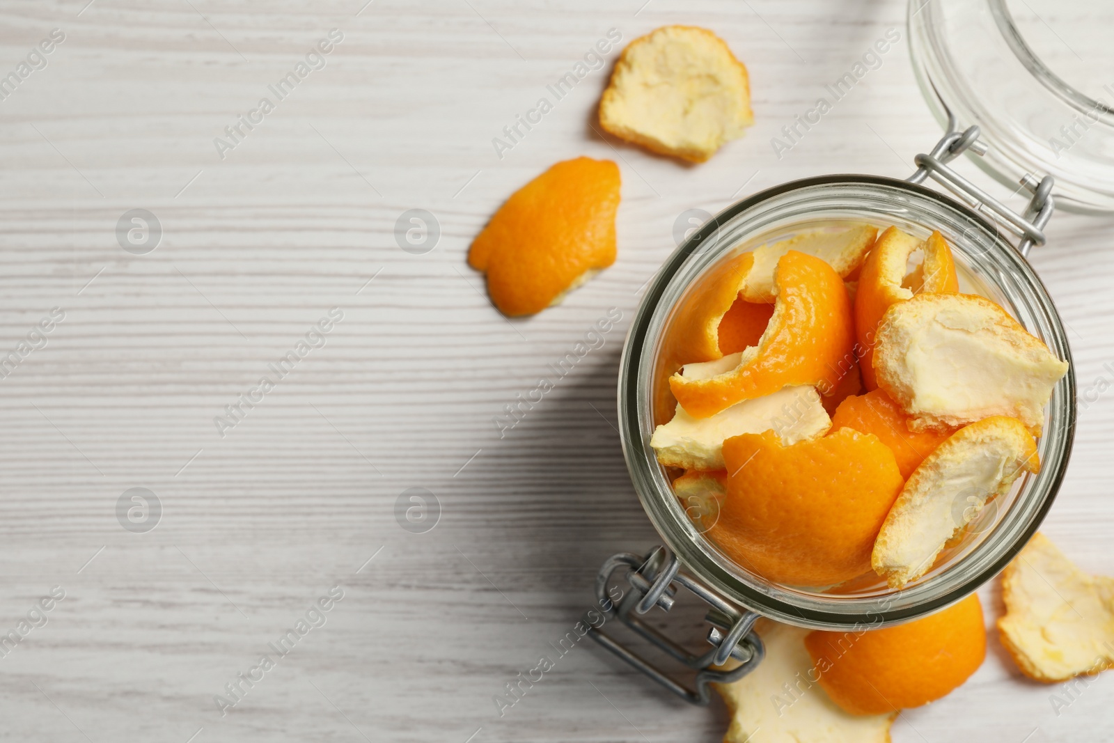 Photo of Orange peels preparing for drying on white wooden table, flat lay. Space for text