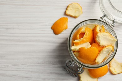 Orange peels preparing for drying on white wooden table, flat lay. Space for text