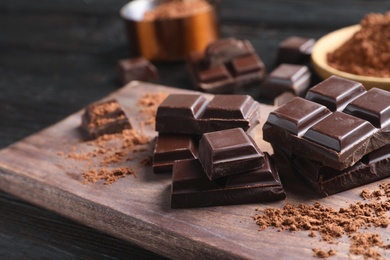 Photo of Pieces of black chocolate on wooden board