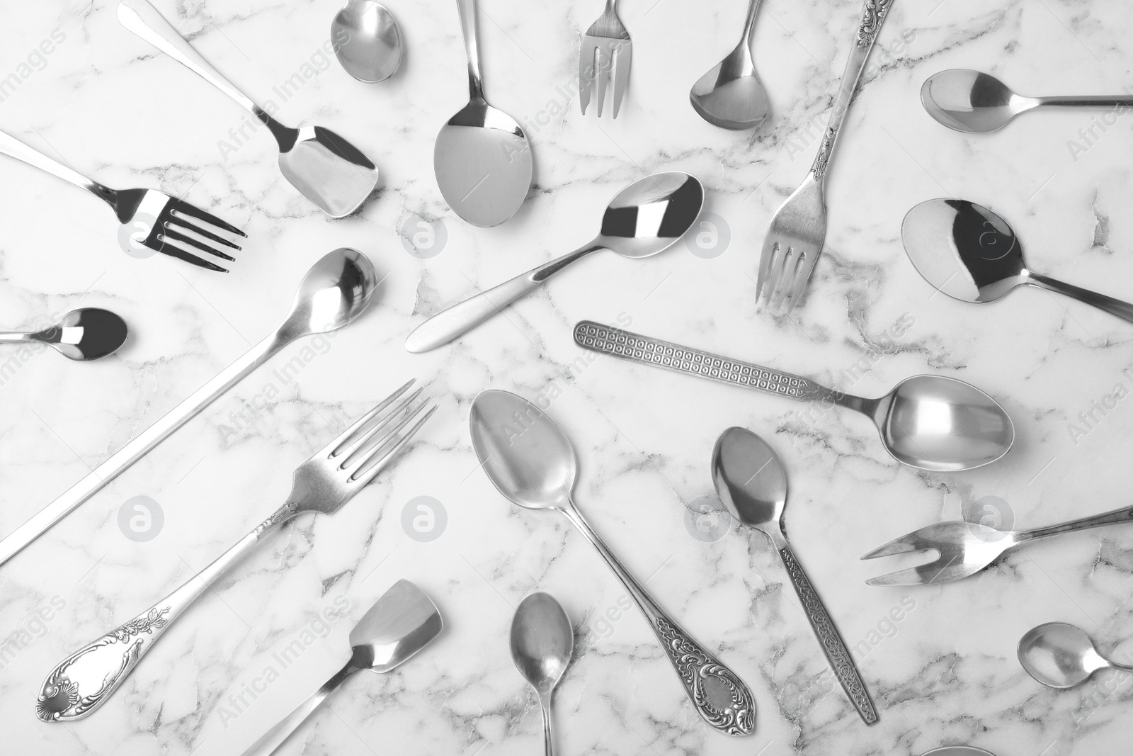 Photo of Set of new luxury cutlery on marble table, flat lay