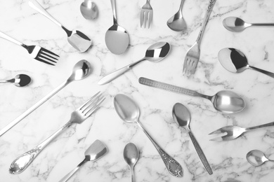 Photo of Set of new luxury cutlery on marble table, flat lay
