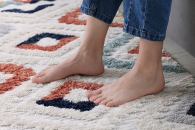 Woman on carpet with pattern at home, closeup