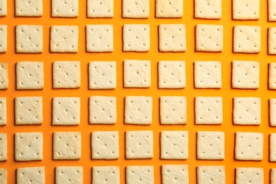 Photo of Delicious crackers on orange background, flat lay