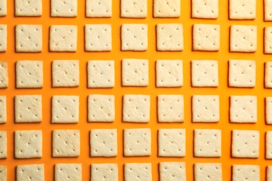 Delicious crackers on orange background, flat lay