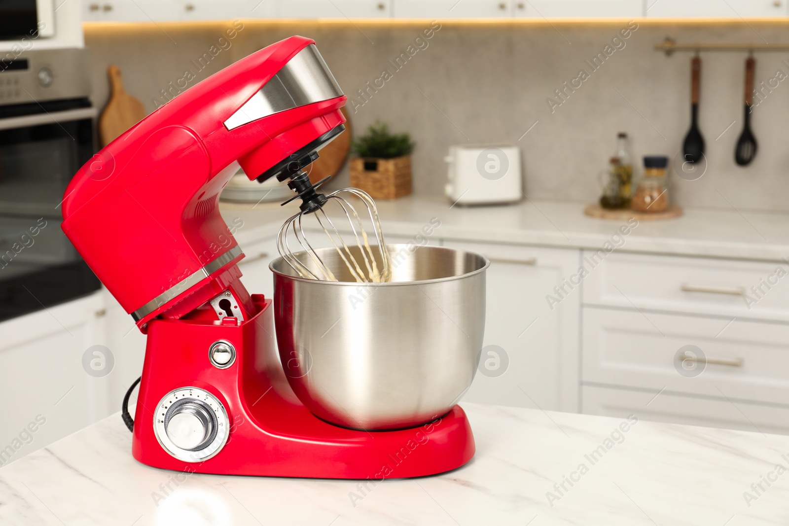 Photo of Modern red stand mixer on white marble table in kitchen, space for text