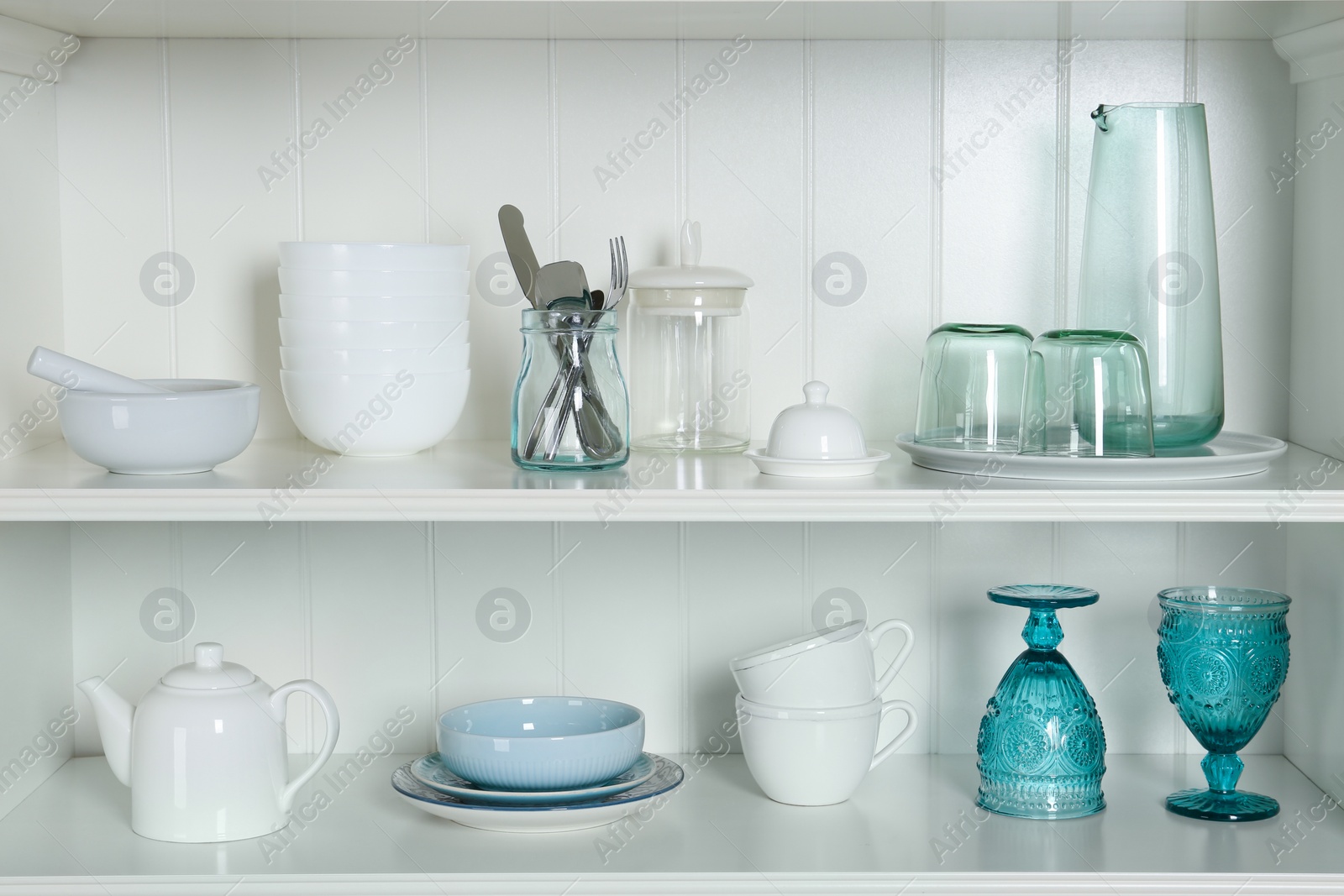 Photo of White shelving unit with set of dishware