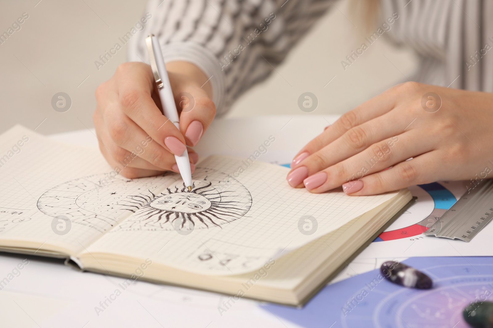 Photo of Astrologer using zodiac wheel for fate forecast at table, closeup. Fortune telling