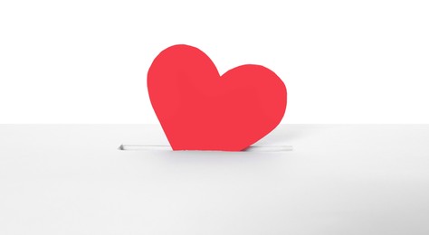 Photo of Red heart into slot of donation box against white background