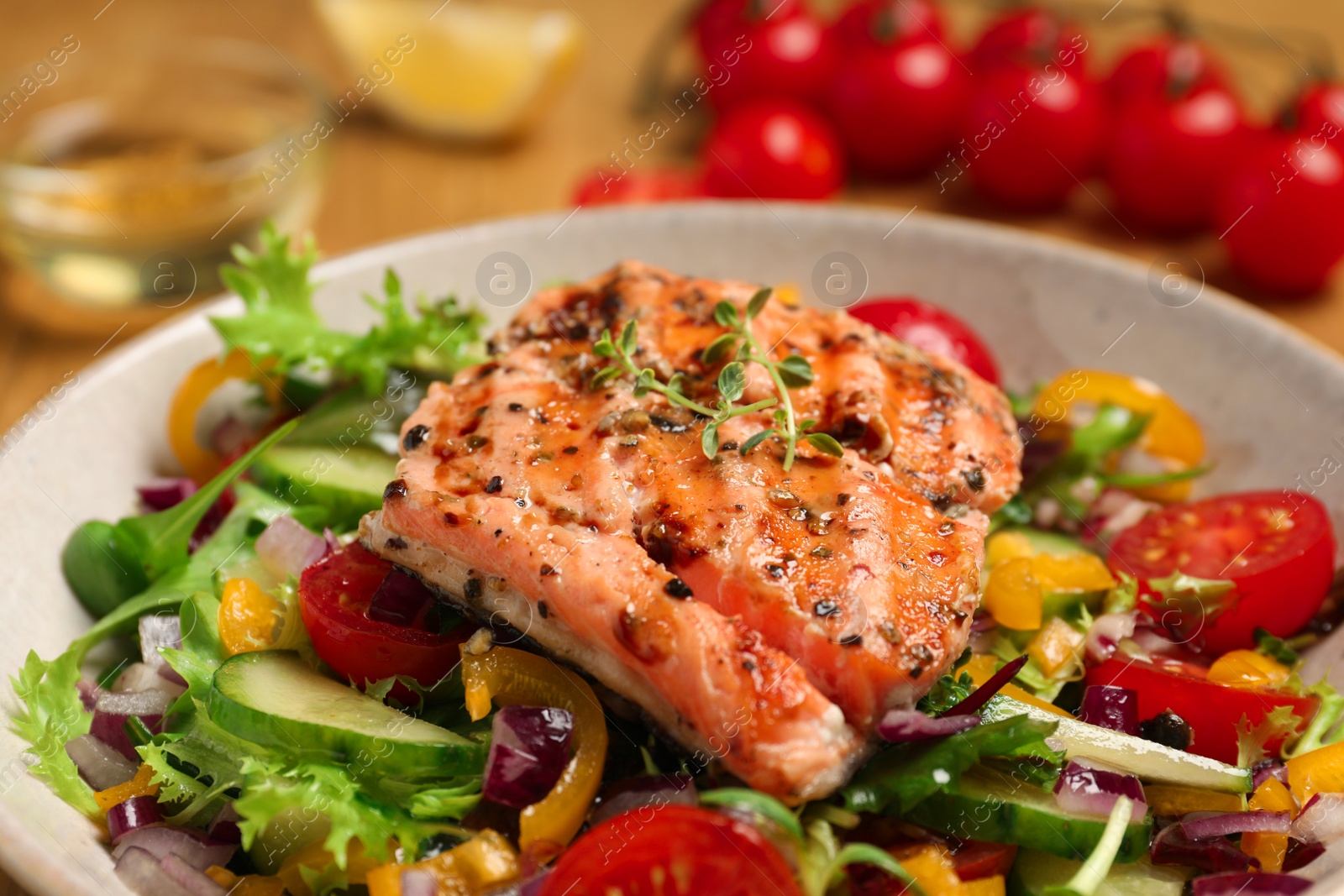 Photo of Bowl with tasty salmon piece and mixed vegetables on table, closeup