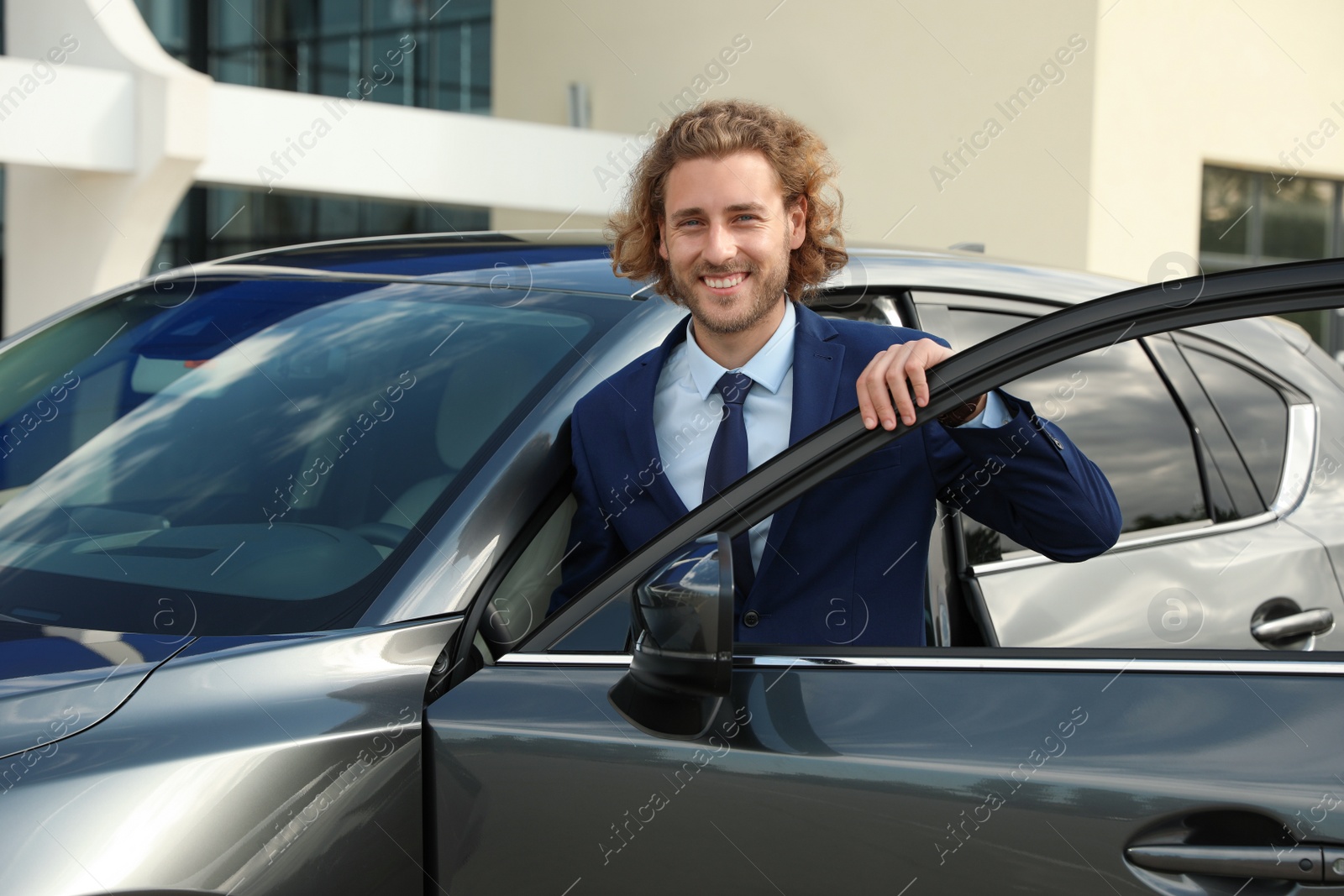 Photo of Attractive young man near luxury car outdoors