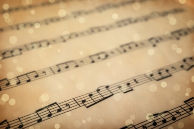 Image of Old sheet with Christmas music notes as background, bokeh effect