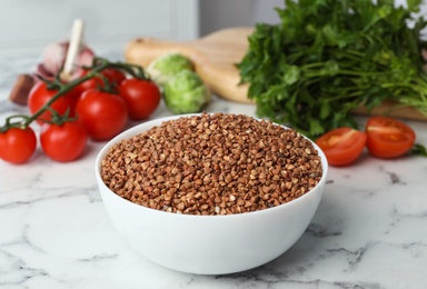 Buckwheat grains on white marble table indoors