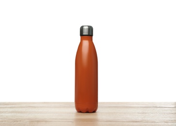 Stylish thermo bottle on wooden table against white background