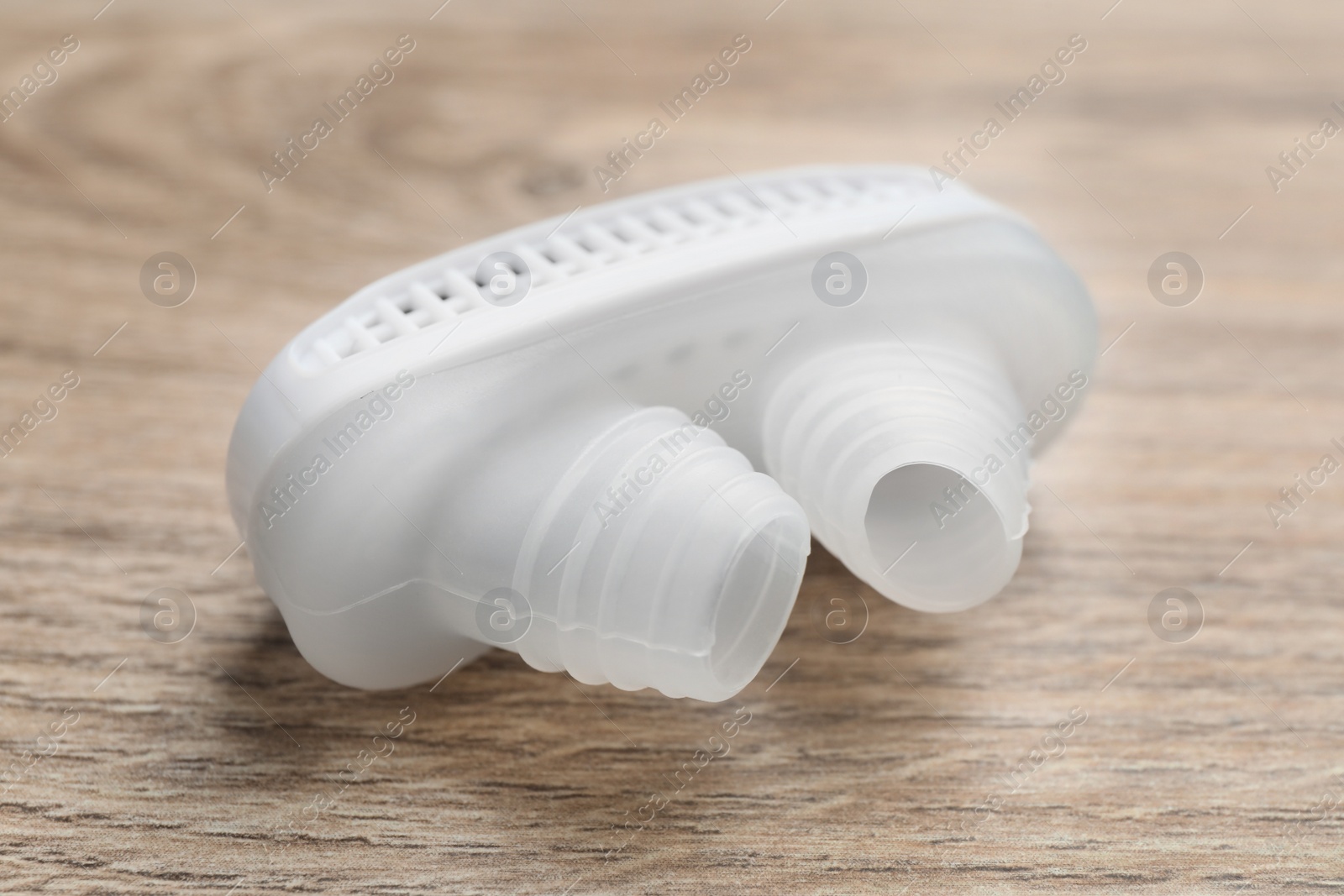 Photo of Anti-snoring device for nose on wooden table, closeup