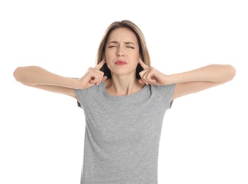 Photo of Emotional young woman covering her ears with fingers on white background