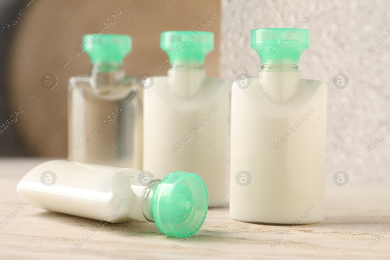 Photo of Mini bottles of cosmetic products on white wooden table