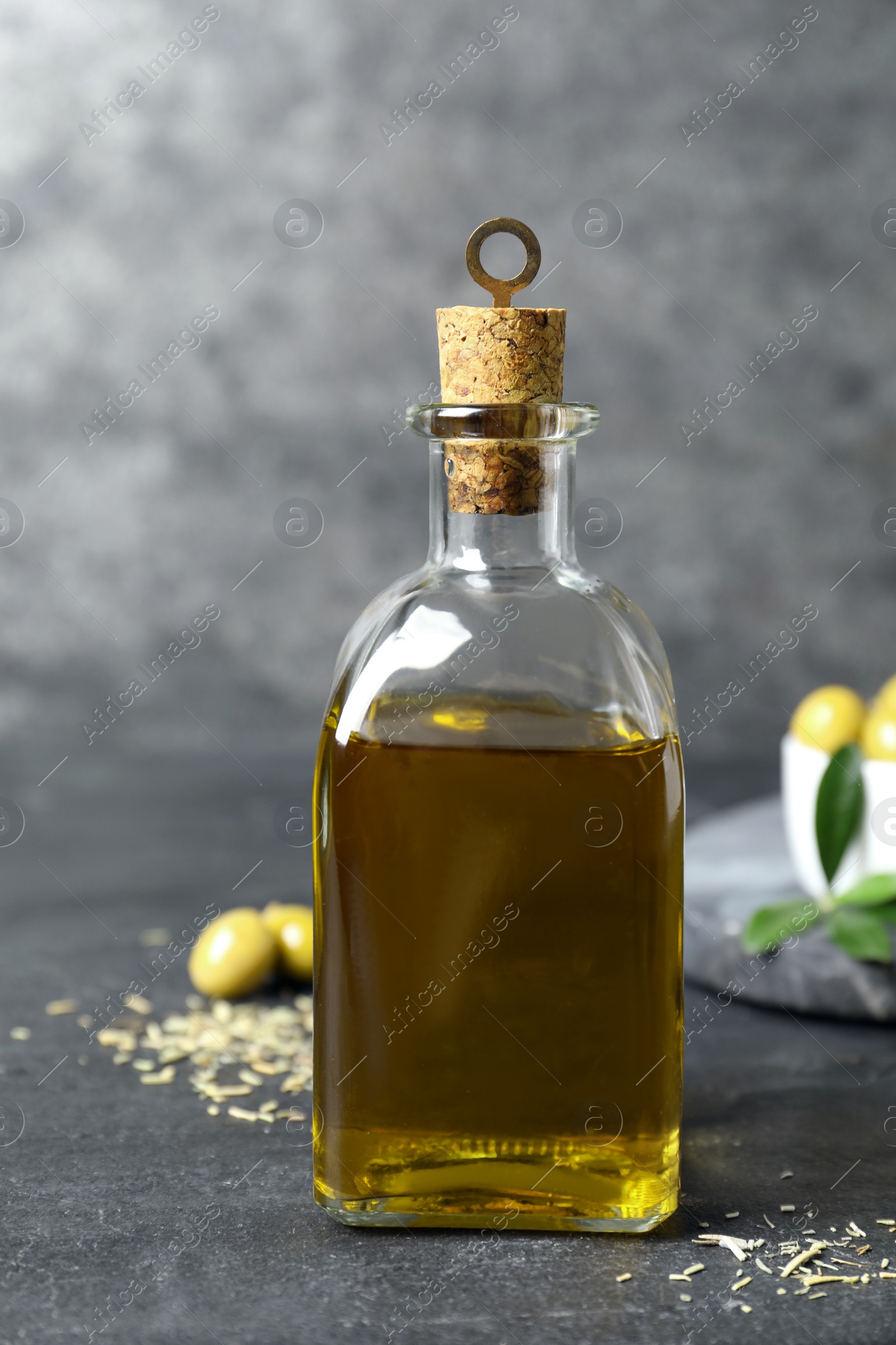 Photo of Bottle of fresh olive oil on dark grey table