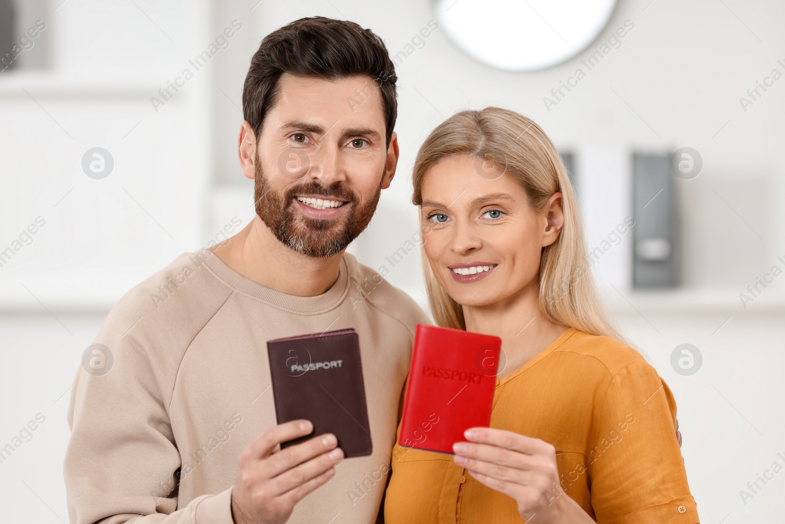 Photo of Immigration. Happy man and woman with passports indoors