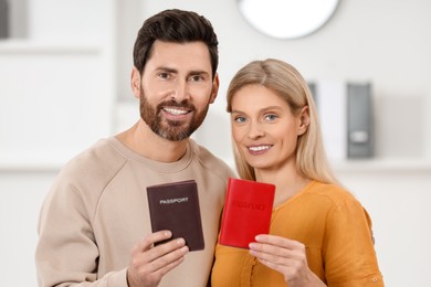 Photo of Immigration. Happy man and woman with passports indoors