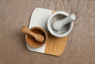 Photo of Clean mortars with pestles on wooden table, top view. Cooking utensils