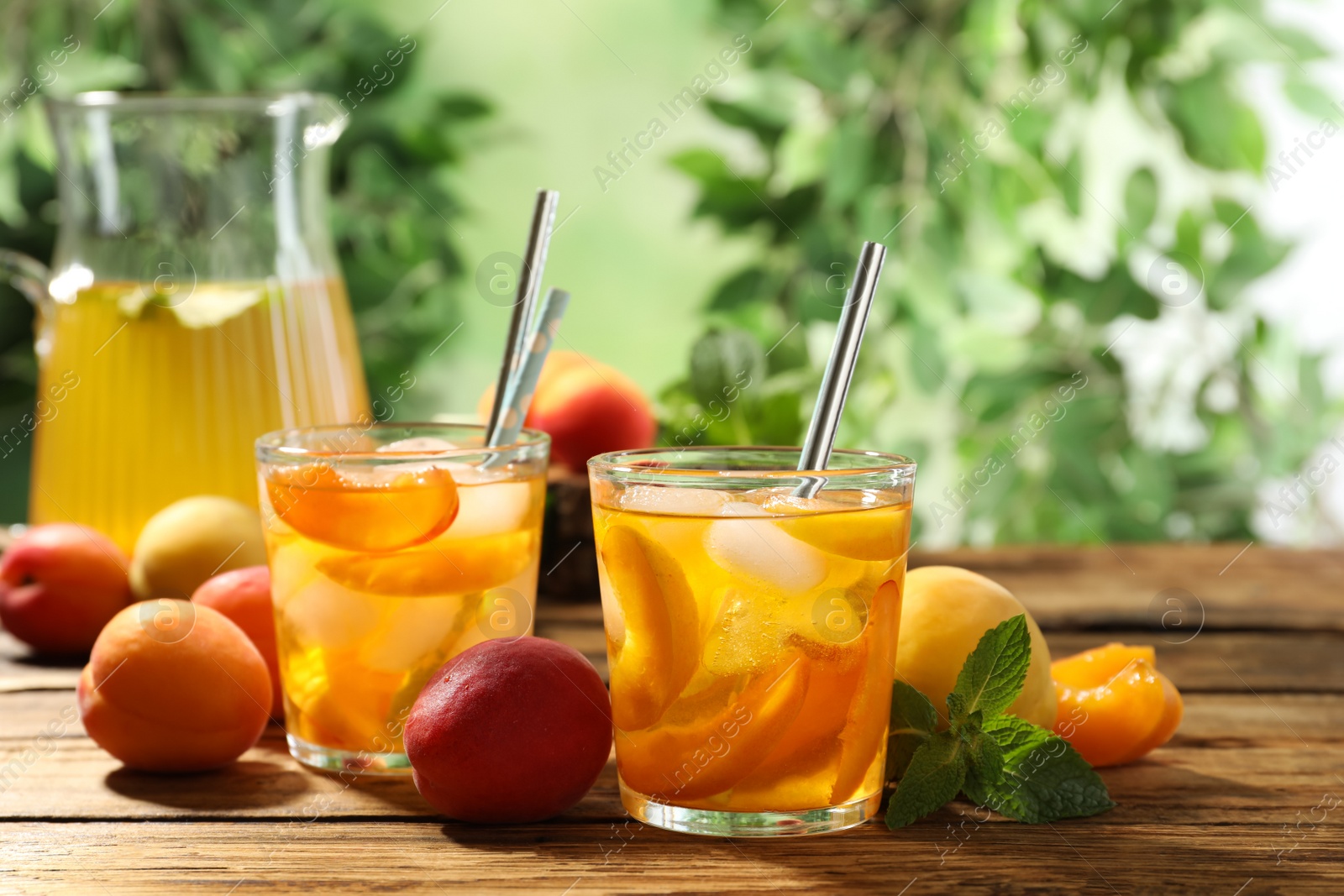 Photo of Delicious refreshing drink with apricot on wooden table