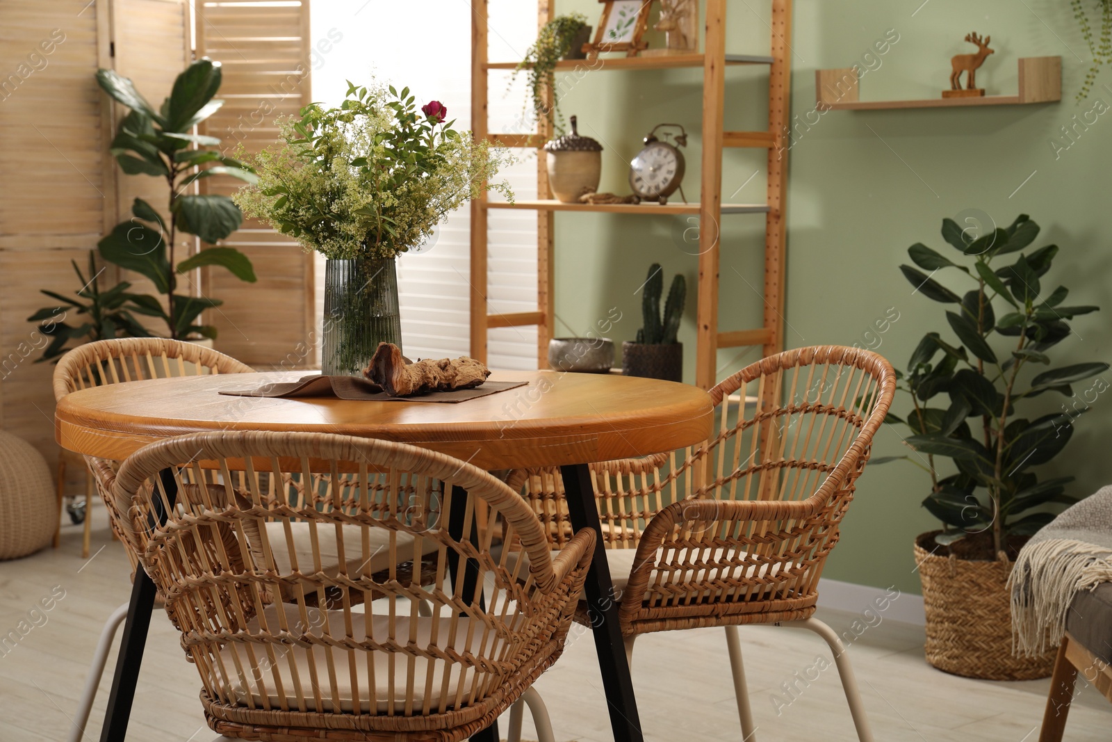 Photo of Stylish dining room interior with wooden table and rattan chairs