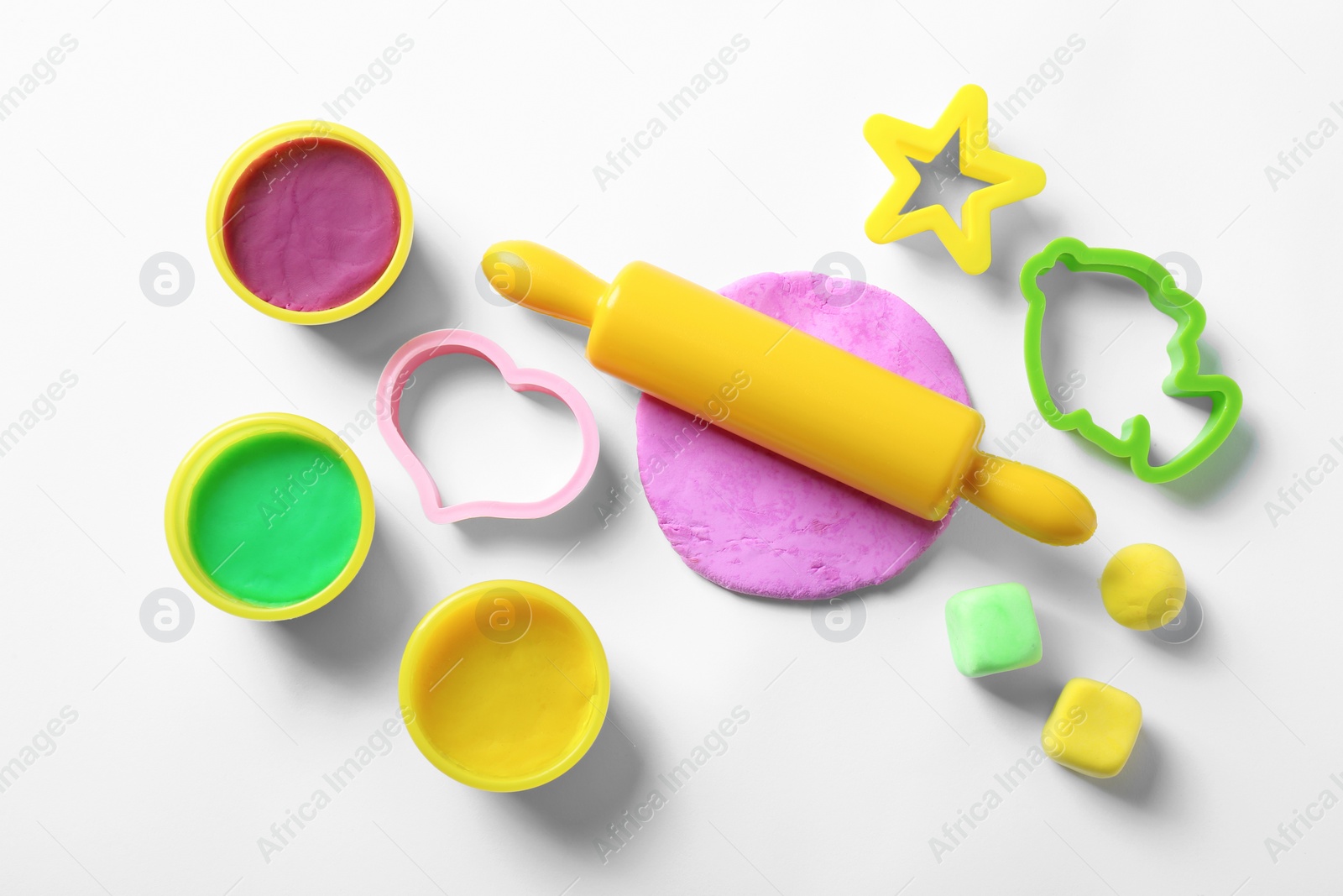 Photo of Set of tools and color play dough on white background, top view