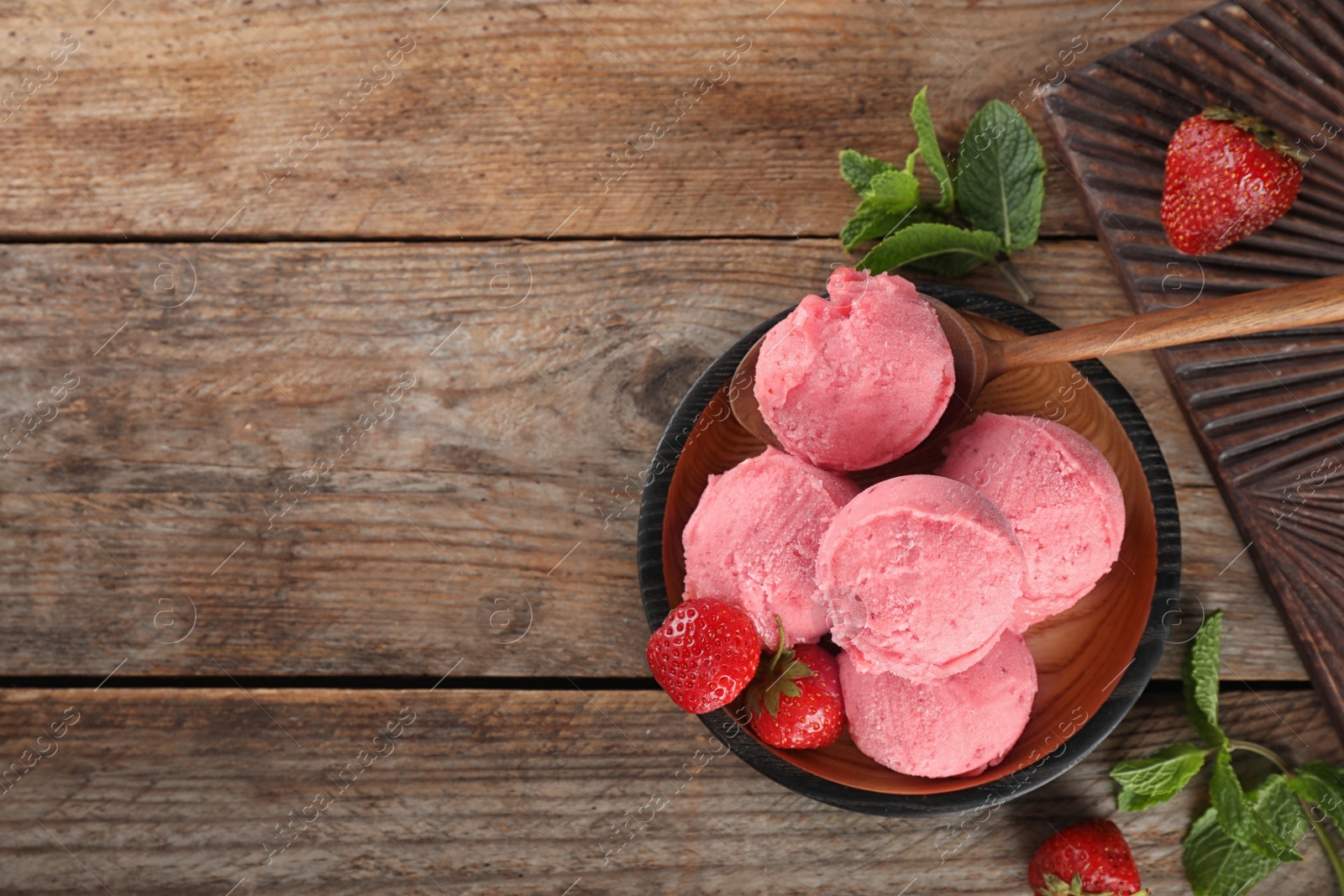 Photo of Plate with delicious strawberry ice cream on wooden table, top view. Space for text