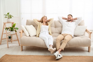 Photo of Couple relaxing on sofa in living room