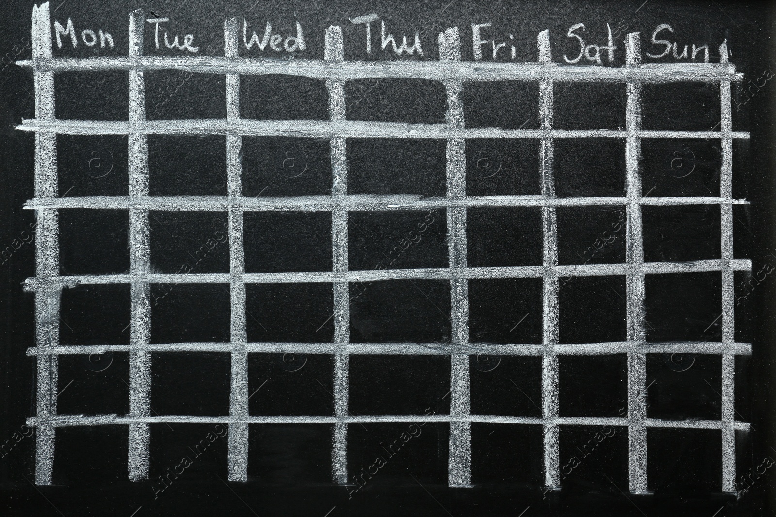 Photo of Weekly school timetable drawn on black chalkboard