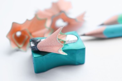 Pencils, sharpener and shavings on white background, closeup