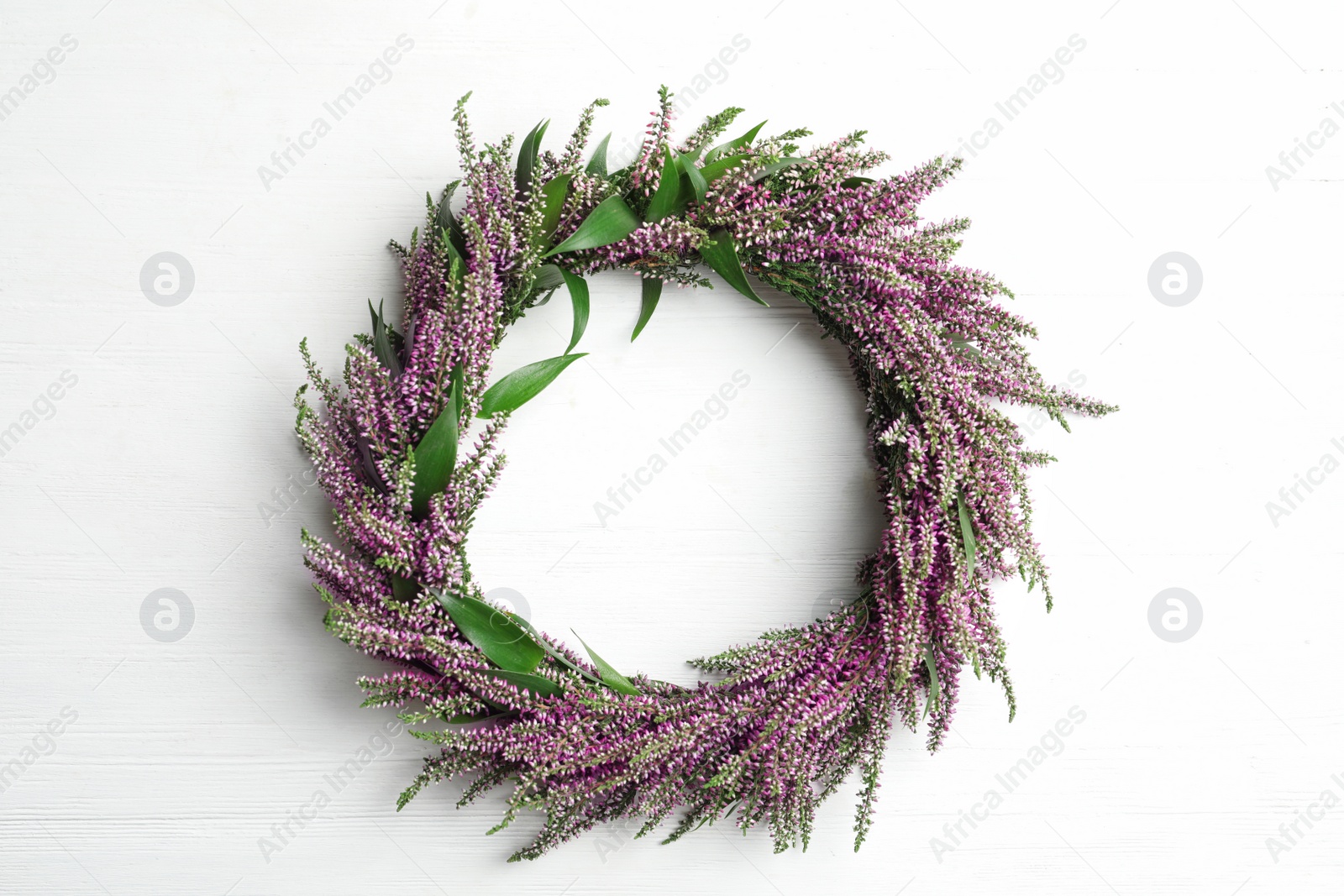 Photo of Beautiful autumnal wreath with heather flowers on white background, top view. Space for text