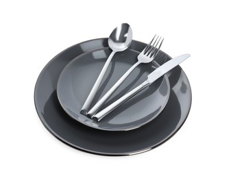 Photo of Plate with shiny silver cutlery on white background